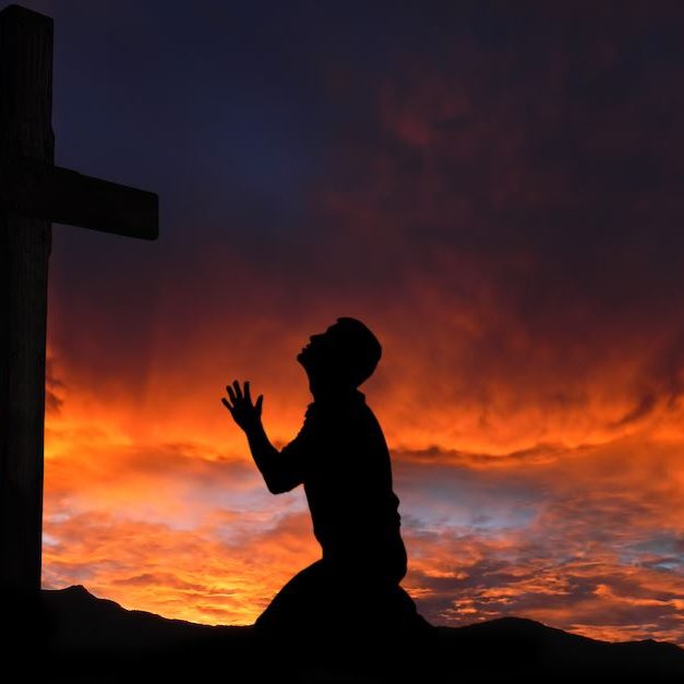 Dramatic sky scenery with a mountain cross and a worshiper